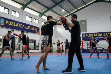Atlet-atlet bela diri Jawa Timur dari berbagai cabang olahraga sedang menjalani sesi latihan intensif di fasilitas PUSLATDA JATIM. Latihan ini merupakan bagian dari persiapan selektif menuju PON Bela Diri II 2026. (Foto Ilustrasi AI)